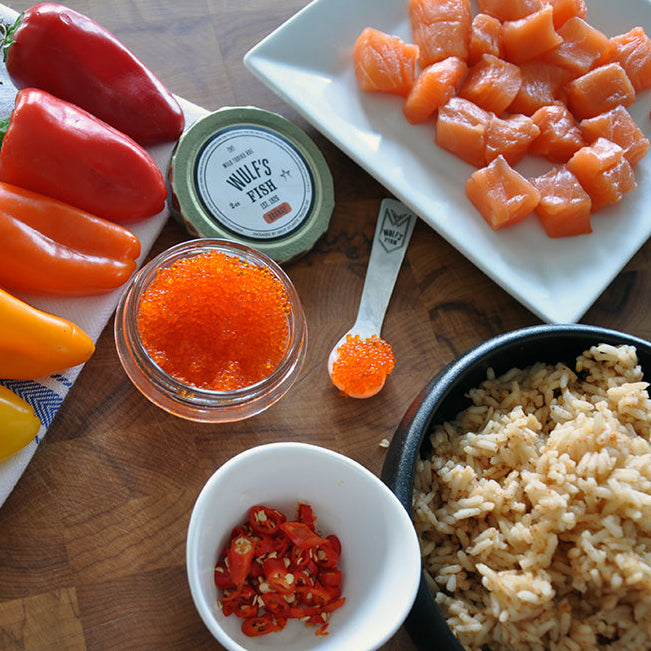 Salmon poke ingredients with roe and peppers and rice